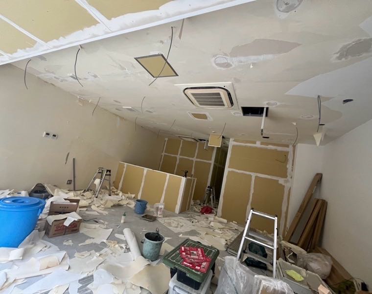 施工前：天井のクロスを半分ほど剥がし、下地とダクトが見えている状態